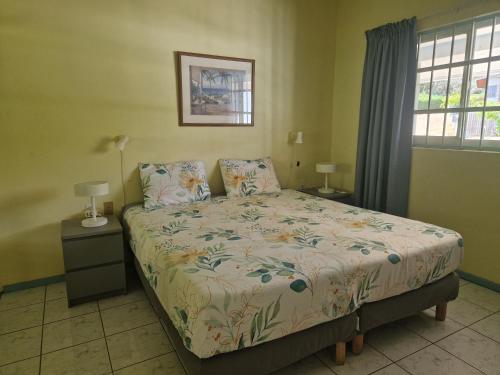 a bedroom with a bed and two lamps and a window at Seru Coral Resort Appartement 188 in Willemstad