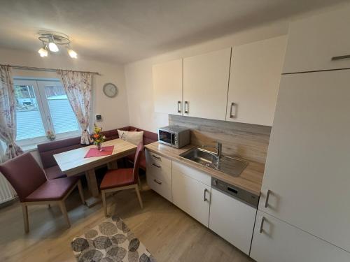 a kitchen with a table and a sink and a microwave at Villa Helga Am Steinernem Meer in Saalfelden am Steinernen Meer