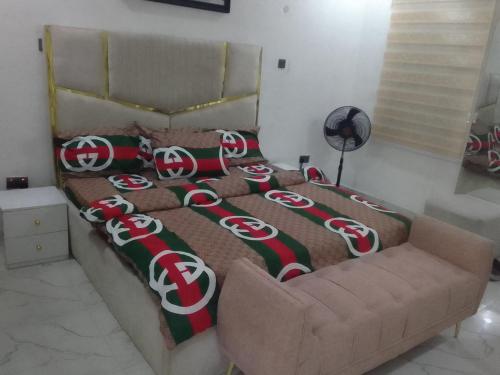 a bed with a olympics blanket and a couch at Xelent Homes in Lekki