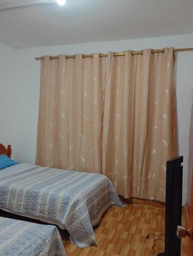 a bedroom with a bed and a curtain at Casa RRR in Caleta Cruz