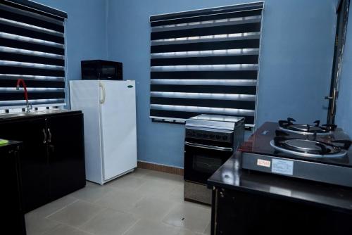 a kitchen with a white refrigerator and a stove at Villa 29 in Enugu