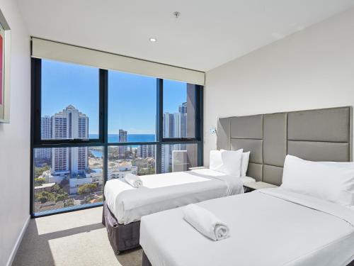 a hotel room with two beds and a large window at Ruby Apartment Gold Coast in Gold Coast