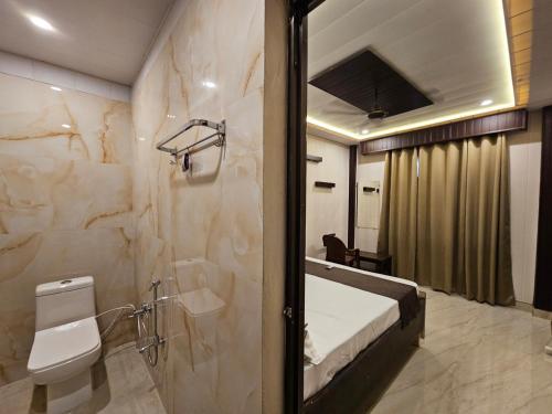 a bathroom with a bed and a toilet and a shower at Chhaya Niketan Home Stay in Ayodhya
