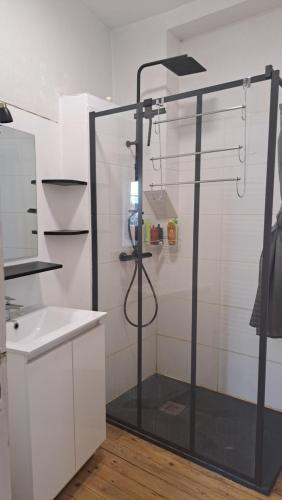 une douche avec une porte vitrée dans une salle de bain dans l'établissement Maison centre Connerré - Proche 24h - 11 pers - 4 chambres, à Connerré