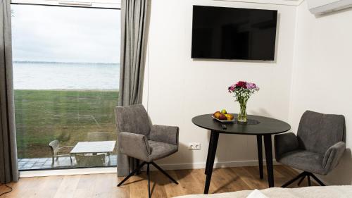 a living room with a table and chairs and a window at Domki Dollar -Plaża Nowe Guty in Nowe Guty