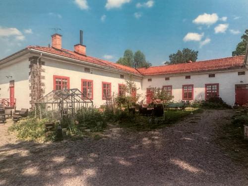 a large white building with red windows at Superfin lägenhet 2 rok Söderfors wärdshus in Söderfors