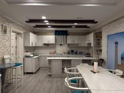 a kitchen with wooden cabinets and tables and chairs at Hotel Taht in Tashkent