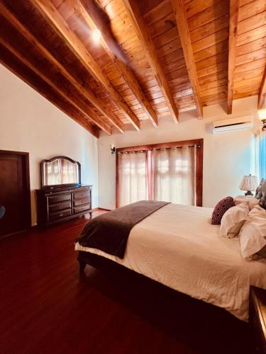 a bedroom with a large bed and a wooden ceiling at Villa Corsua in Valle de Guadalupe