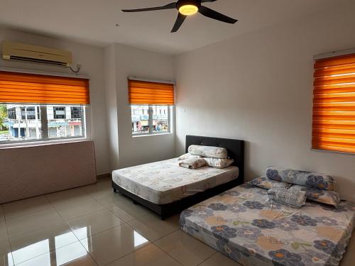 a bedroom with two beds and a ceiling fan at 班台212民宿 Pantai Remis in Pantai Remis