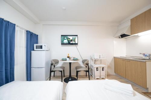a small room with a kitchen and a table with chairs at Home Story in Tokyo 江戸川区平井駅-上野 秋葉原まで直通 in Tokyo