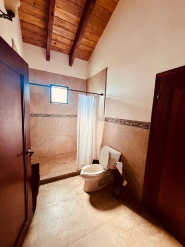 a bathroom with a toilet and a window at Villa Corsua in Valle de Guadalupe