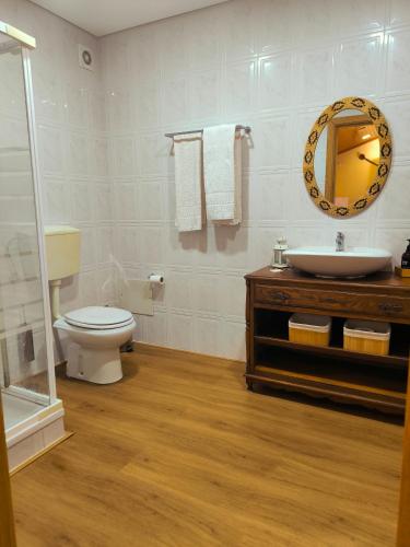 a bathroom with a sink and a toilet and a mirror at Casa Tertúlia in Covão do Coelho