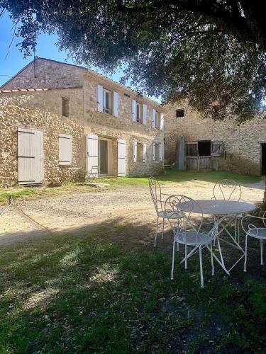 a table and chairs in front of a building at Studio cosy à la campagne in Montjustin