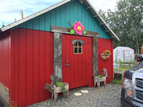 a red shed with a flower on the door at Klutina Kate's B&B in Copper Center