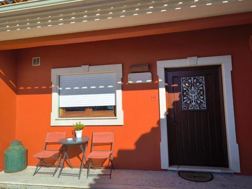 a house with chairs and a table and a door at Casa Tertúlia in Covão do Coelho
