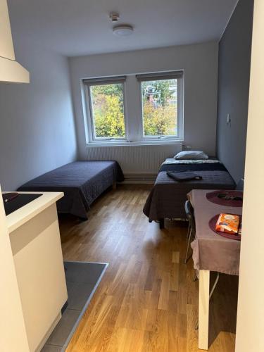 two beds in a room with two windows at Apartment 17 in Sollentuna in Sollentuna