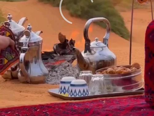 a table with two tea pots and a tray of food at Serenity Camp in Wadi Rum
