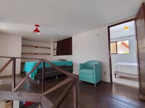 een kamer met een bed en een blauwe stoel bij House 31 Pipa in Pipa