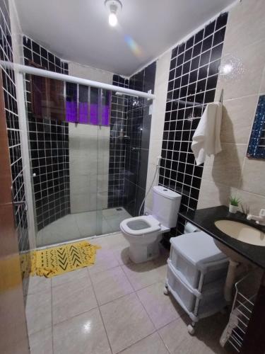 een badkamer met een douche, een toilet en een wastafel bij House 31 Pipa in Pipa