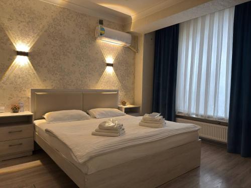 a bedroom with a large bed with towels on it at Hotel Taht in Tashkent