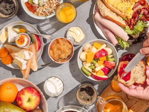 a table topped with plates of food and bowls of fruit at ibis Beauvais Aéroport in Beauvais