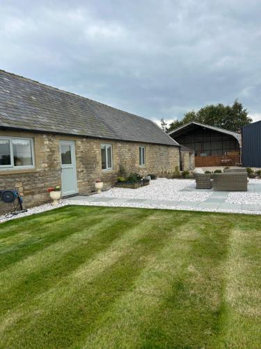 a backyard of a house with a grass yard at High Shilford Barn in Ridingmill