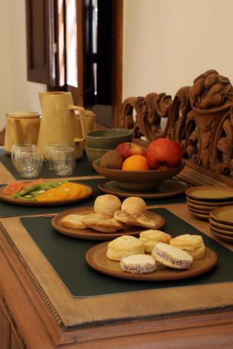 a table with plates of cookies and fruit on it at Boutique Hotel Bodega CICLO ANDINO in Perdriel