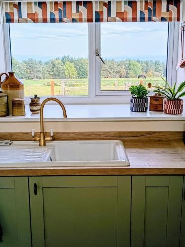 a kitchen counter with a sink and a window at High Shilford Barn in Ridingmill