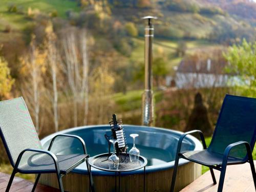 a table with two chairs and a bath tub at DnD Mountain Escape in Holbav