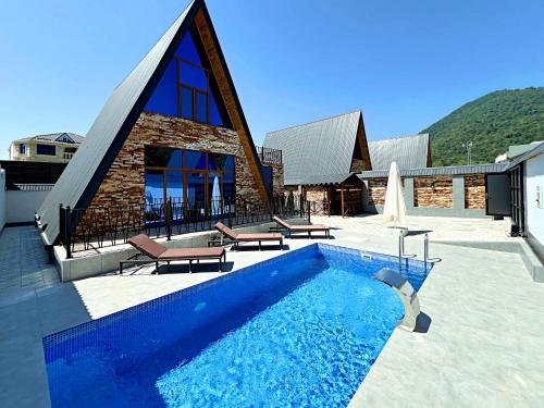 una casa con piscina al lado de un edificio en солнечный, en Mekhrably