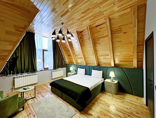 Un dormitorio con una cama grande en una habitación con techos de madera. en солнечный, en Mekhrably