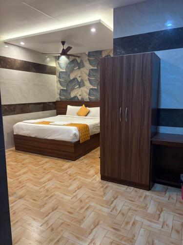 Un dormitorio con una cama y un armario de madera. en NJK Residency, en Yercaud