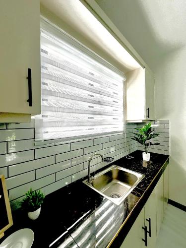 a kitchen with a sink and a window at Sol Y Verde Resort Tagaytay in Ulot