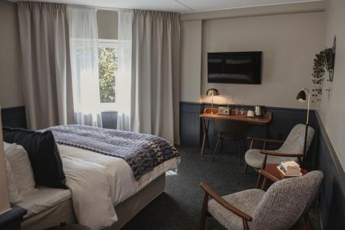 une chambre d'hôtel avec un lit et un bureau dans l'établissement Home Hotel Kompaniet, à Nyköping