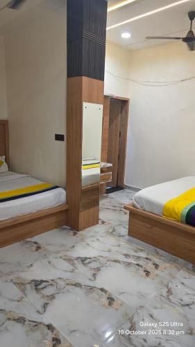 a bedroom with two beds and a marble floor at krishna residency in Mathura
