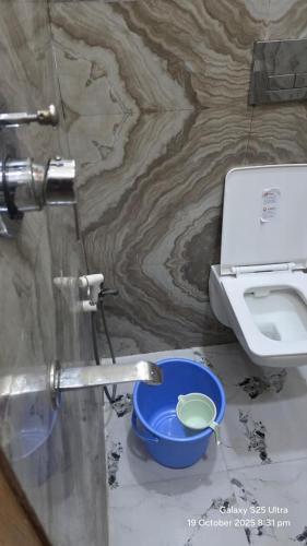 a bathroom with a toilet and a blue bowl at krishna residency in Mathura