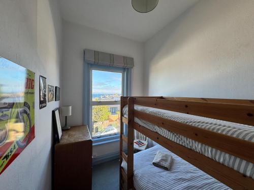 Un dormitorio con una litera y una ventana. en Sea views at Carina centrally located in village, en Seaview