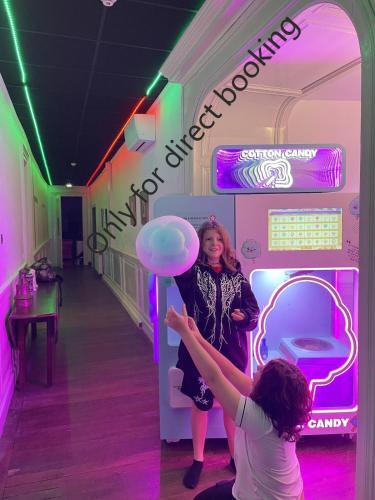 two women are standing in a room with a neon sign at Château de Seurre No Boring People in Seurre
