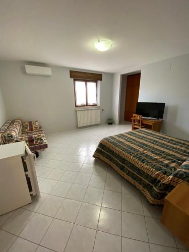 a bedroom with two beds and a desk and a window at Bed and Breakfast "POGGIO MARANO" in San Bartolomeo in Galdo