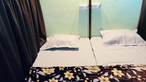 a bed with two pillows on top of it at REST POINT Dormitory in Jaipur