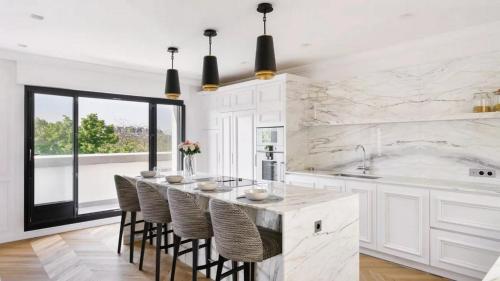 a kitchen with a large island with bar stools at La Défense Eiffel Tower in Puteaux