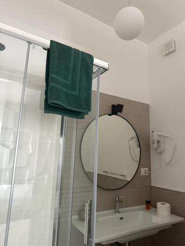 a bathroom with a green towel and a mirror at Dimora del Salento Apartment in Brindisi