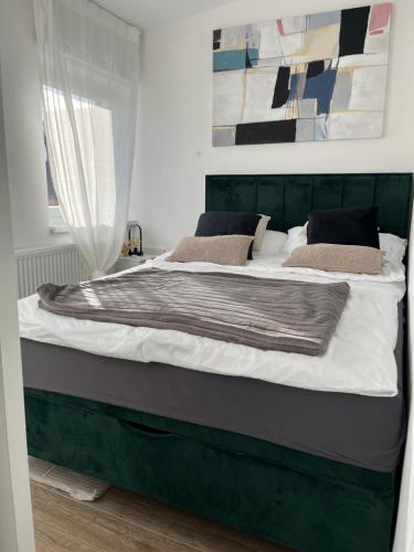 a large bed with a green headboard in a bedroom at LAV apartmani in Karlovac
