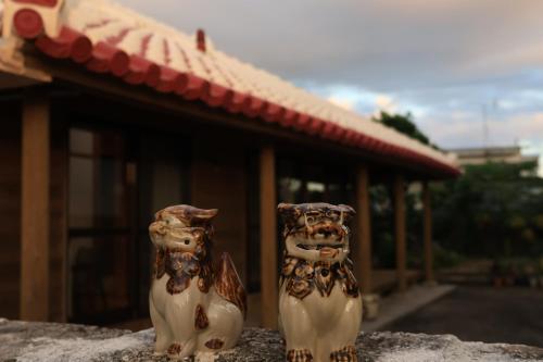 two vases sitting next to each other in front of a building at 田舎の静かな古民家の悠水居 in Itoman