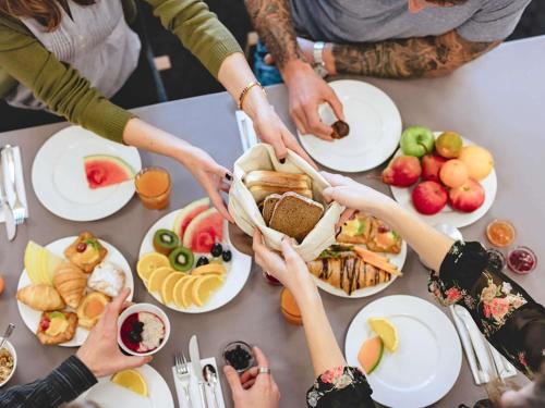 Un grupo de personas tomadas de la mano sobre una mesa con comida. en ibis Belfast Queens Quarter, en Belfast
