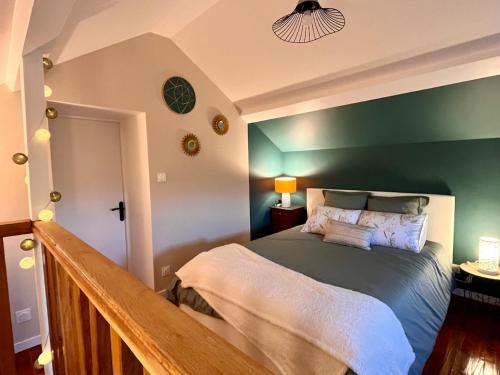 a bedroom with a green accent wall and a bed at La Maisonnette de Chevannes in Sainte-Magnance