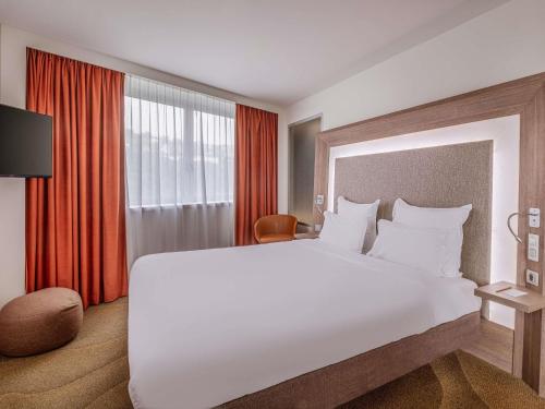 a bedroom with a large white bed and a window at Novotel Lyon Centre-Confluence Bord de Saone in Lyon