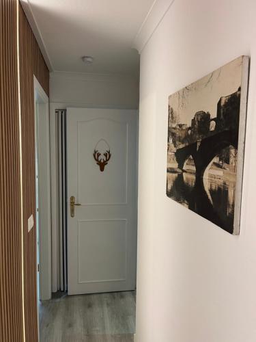 a hallway with a door and a painting on the wall at Le Refuge du Cerf in Bouillon
