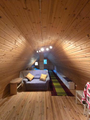 a large room with a bed in a wooden ceiling at Tammetalu puhkemaja 