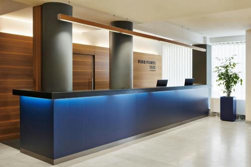 un vestíbulo de oficina con recepción azul en Four Points Flex by Sheraton Vienna Hauptbahnhof, en Viena